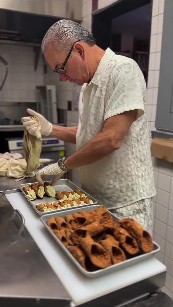 Baby John filling cannoli by hand in the Caffè Palermo kitchen